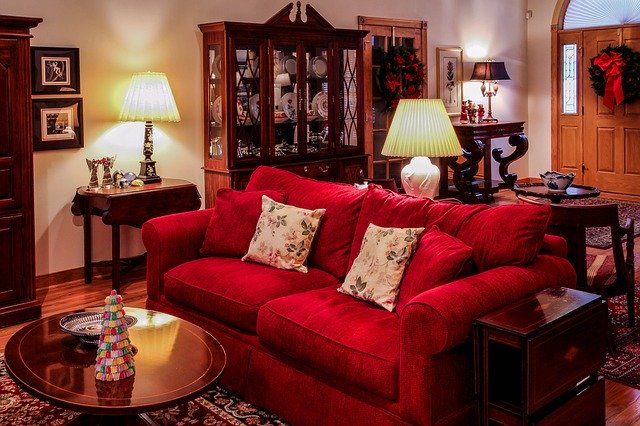 living room decorated with red sofa, lamp and table