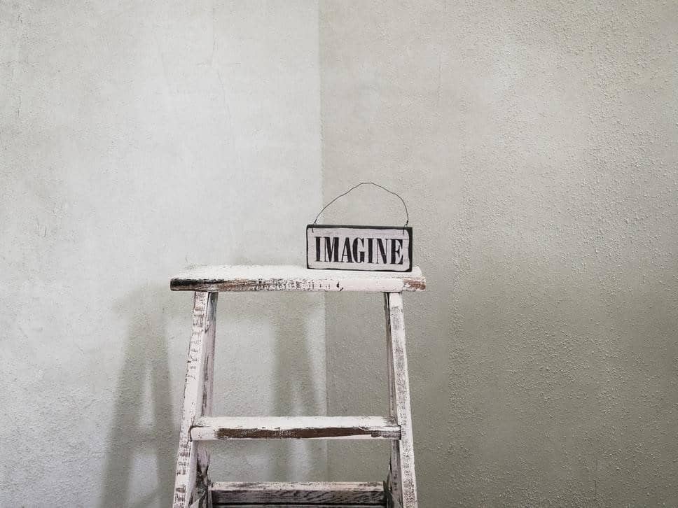 A ladder in the corner of a white room