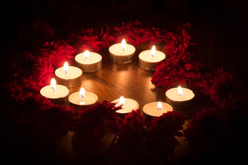 Heart shaped rose petals and candles in bedroom romantic decor